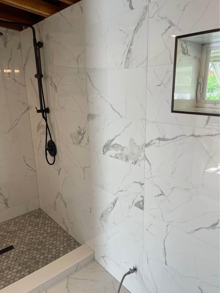 Updated bathroom with tiled walls and a glass shower door