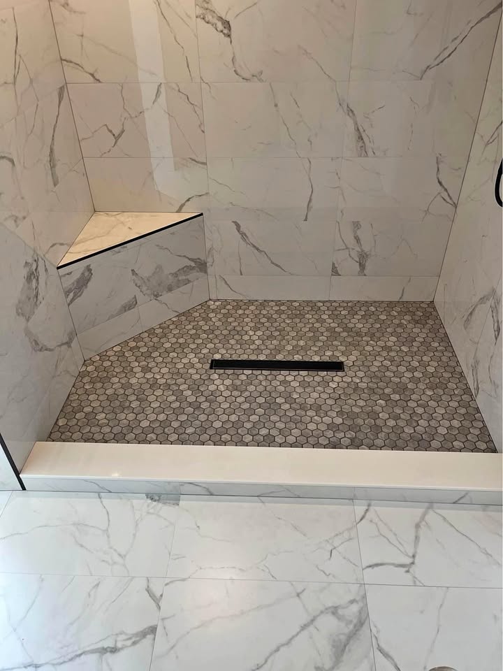 Renovated bathroom with tiled walls and a glass shower enclosure