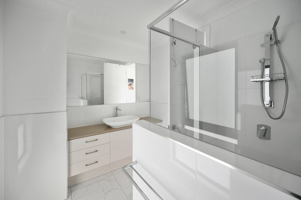 Custom bathroom remodel in Clearwater with a tiled walk-in shower and freestanding vanity